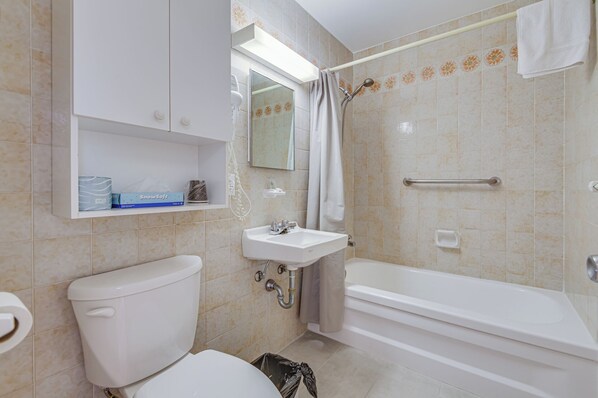 A bathroom with a toilet, sink, and bathtub. - AUBERGE DU MONT RIGAUD (Rigaud)