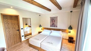 Ein Schlafzimmer mit Holz-Kopfteil, einem Bett mit weißer Bettwäsche, einem Spiegel, einem Wandbild und Nachttischlampen.