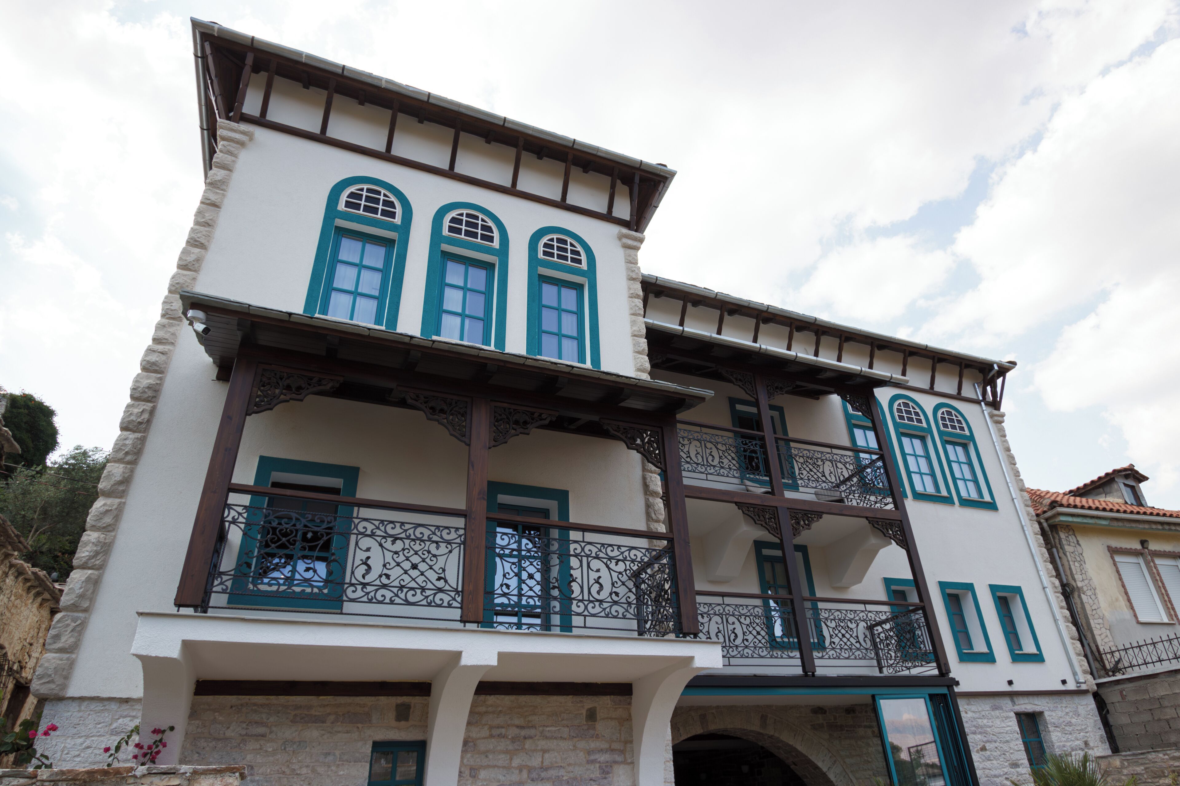 Un bâtiment à deux étages doté d’un balcon, de murs en pierre et d’un style architectural traditionnel.