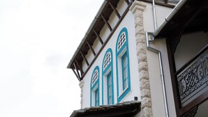 A building with a stone facade, wooden beams, and decorative metal railings. - Cumaku Boutique Hotel & Spa (Gjirokastër)
