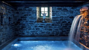 A stone-walled room with a small window, a stone bench, and a water feature. - Cumaku Boutique Hotel & Spa (Gjirokastër)