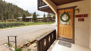 L’entrée d’un hôtel, avec une porte en bois, une guirlande de bienvenue et une enseigne indiquant « KNOTTY PINE ».