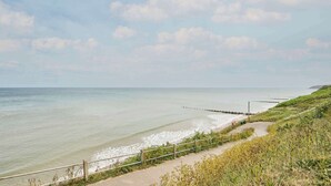 A coastal pathway with a wooden fence, leading to a sandy beach and the sea. - Host & Stay | The Beach House (Overstrand)