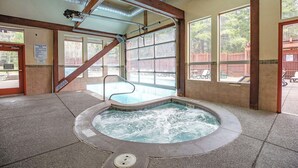 A hot tub area with a view of a wooden deck and a fenced yard. - Trails End Après Penthouse Condo - Ski In/Out, Walk Downtown! (Breckenridge)