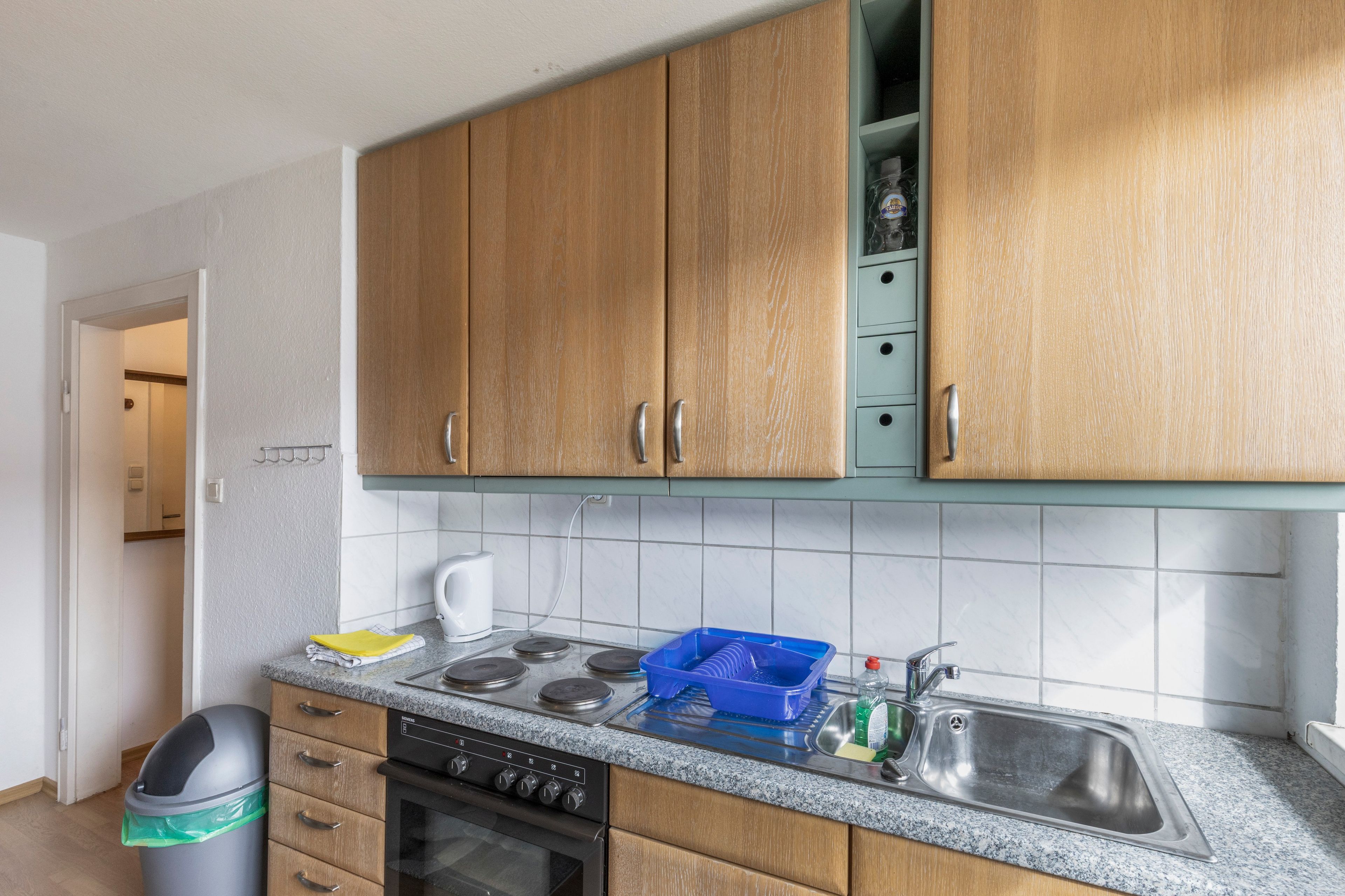 Une cuisine avec des meubles en bois, un évier en acier inoxydable, un lave-vaisselle et une cuisinière.