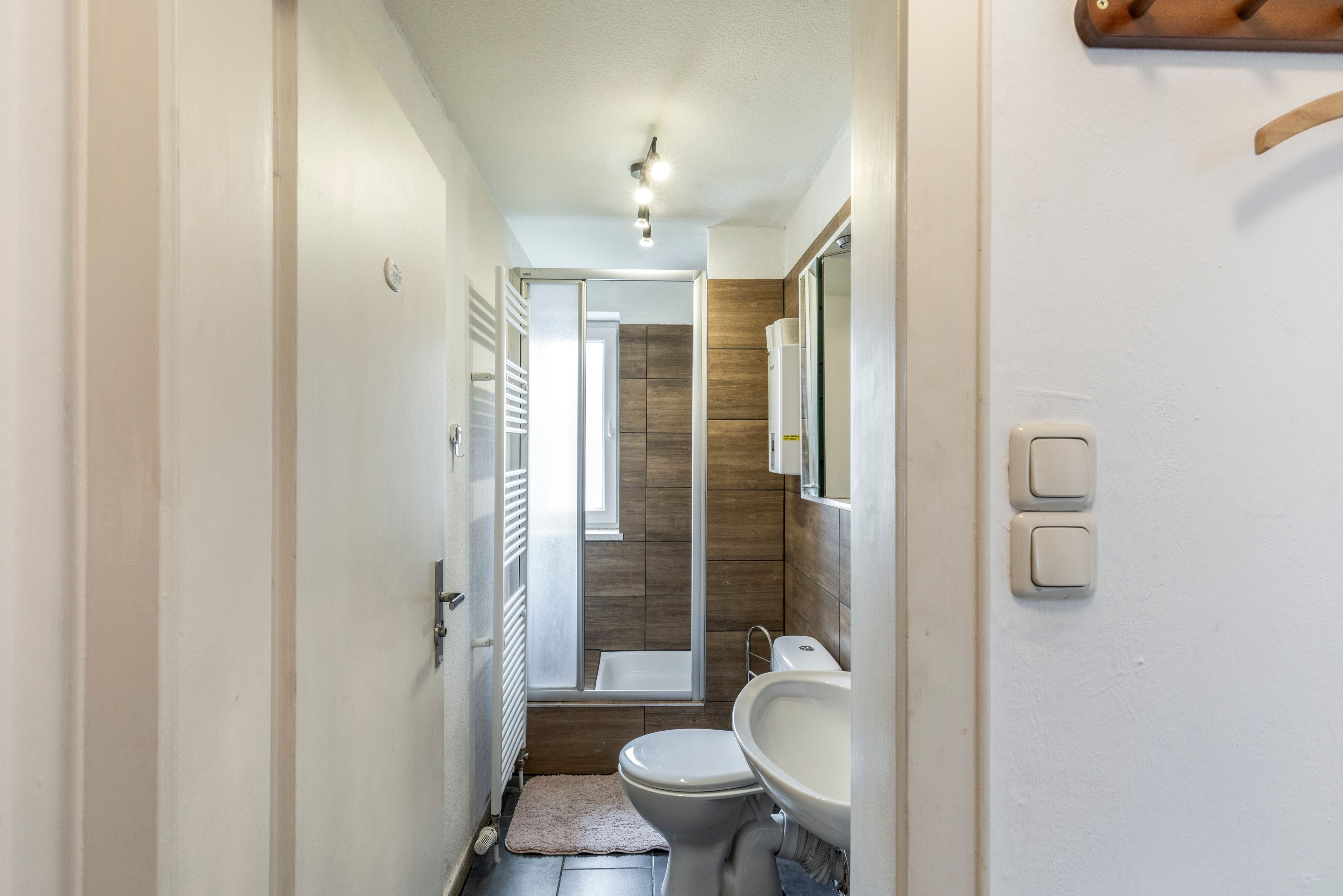 Een kleine badkamer met toilet, wastafel en spiegel.