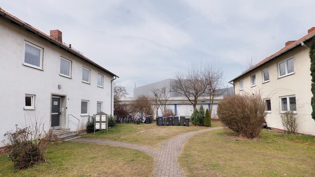 A courtyard with a paved path, buildings with multiple windows, and a few trees. - Holiday Apartment 'D' in Miltenberg (Miltenberg)