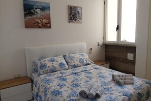1 dormitorio y tabla de planchar con plancha