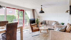 Moderni olohuone, jossa on sohva, sohvapöytä ja ruokailutila.