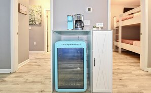 A compact kitchenette with a Frigidaire refrigerator, a coffee maker, and a sign welcoming guests to the coffee nook.