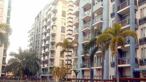 A residential building with multiple balconies, a swimming pool, and palm trees. - One Palm Tree Villas Condo (Pasay)