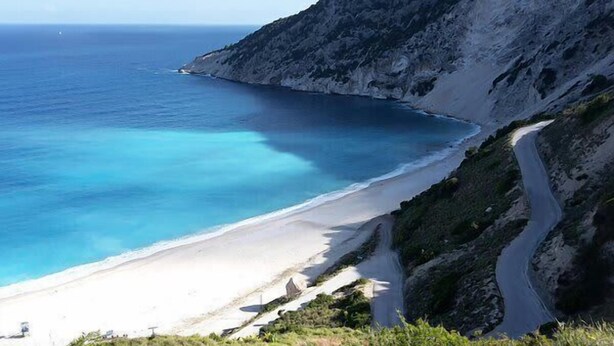 A coastal road leading to a beach with clear blue waters and a rocky cliff. - Skordalos Maisonette - Crete Rustic Nest (Viannos)
