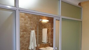 A bathroom with a toilet, sink, and glass shower enclosure. - Nairobi Inn (Syokimau)