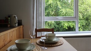 Una tavola imbandita con una ciotola, un bicchiere di vino e un piatto per due persone.