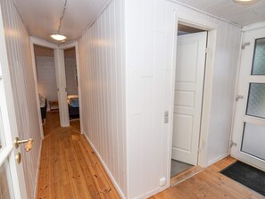 A hallway with wooden flooring, white walls, and a door leading to another room. - 6 Person Holiday Home in Thyholm (Thyholm)