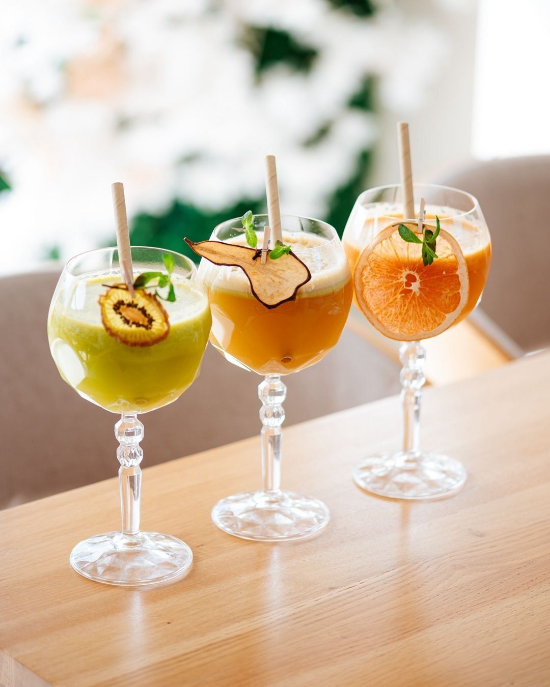 Trois verres remplis de boissons sur une table en bois.