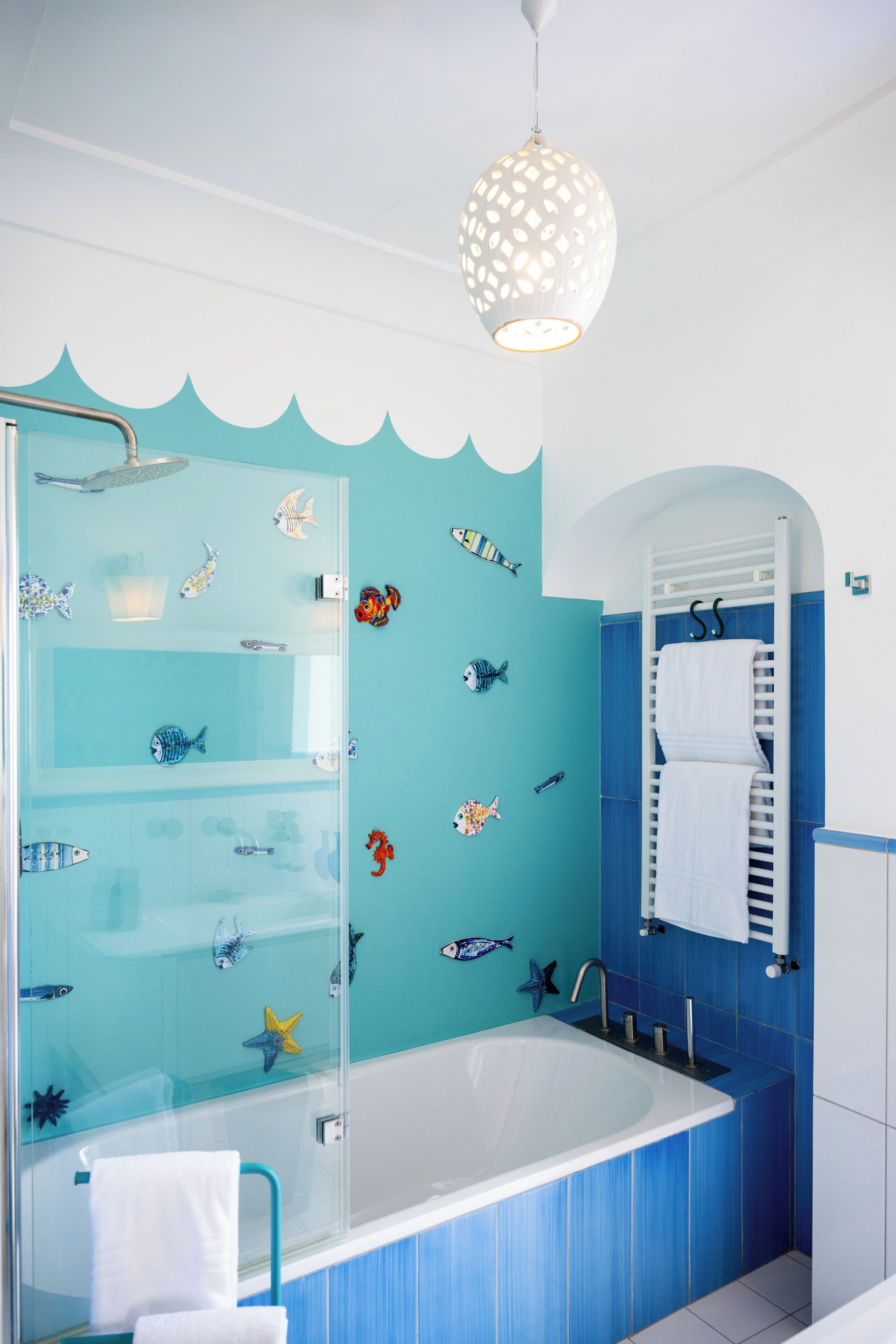 A bathroom with a glass shower enclosure, a bathtub, and a ceiling light fixture.