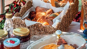 A table with a wicker basket containing bread, a glass jar, and a ceramic dish with food. - Maison Cherie (Positano)