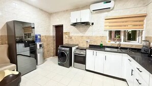 A compact kitchen with a washing machine, stove, and a built-in oven.