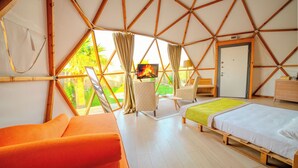 Una habitación con cama, sofá, televisor y una puerta.
