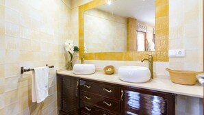 A bathroom with two sinks, a mirror, and a towel rack. - Caballo Tourist Apartment (Lanjarón)