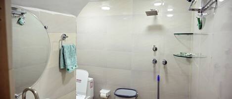 A bathroom with a sink, toilet, mirror, shower, and a towel rack.
