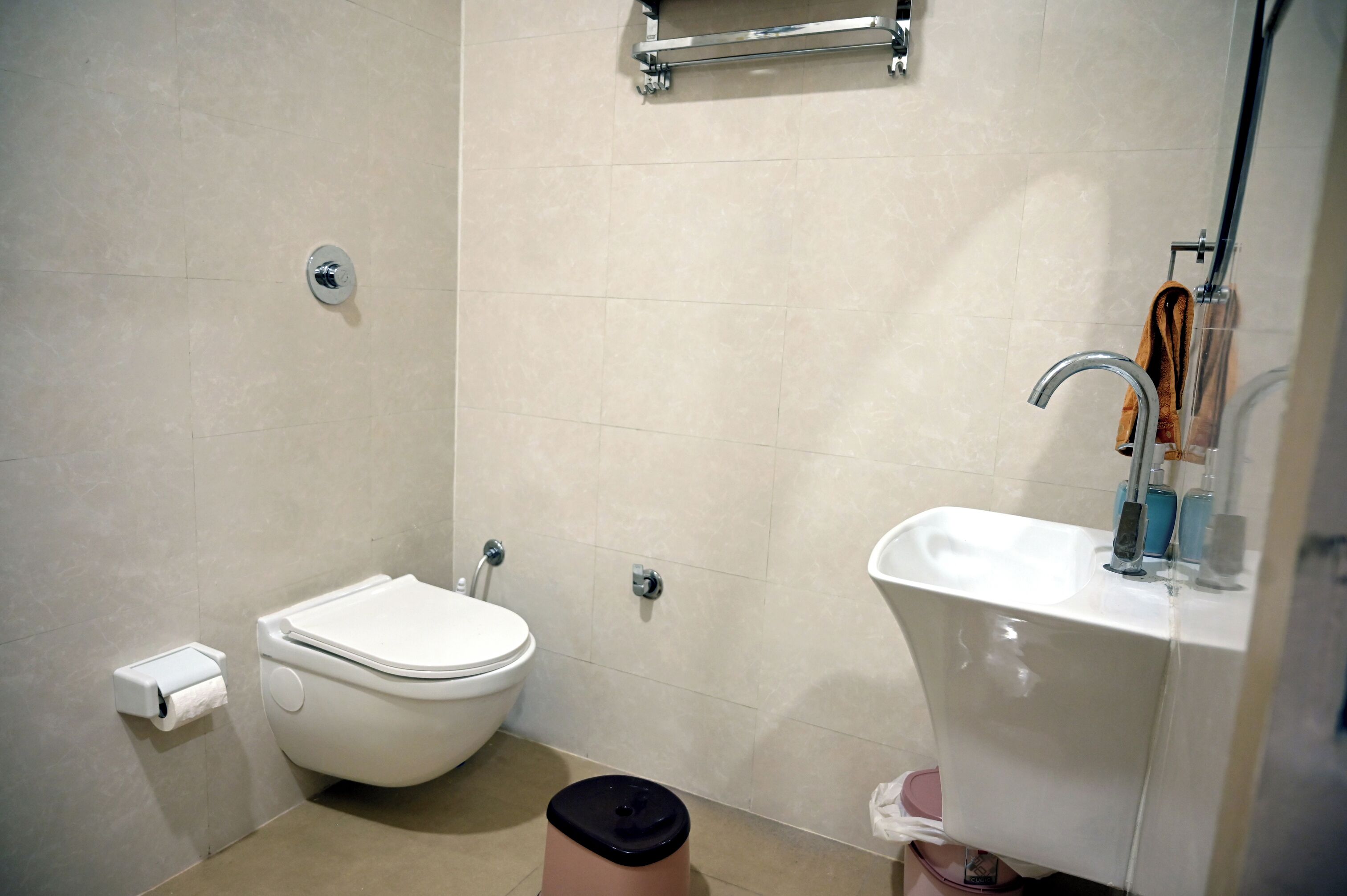 A compact bathroom with a toilet, sink, and shower.