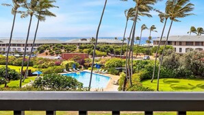 A pool area with lounge chairs and a view of the ocean. - Kauai Poipu Sands 222 2 Bedroom Condo (Koloa)