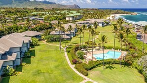 A resort with multiple buildings, a swimming pool, and a view of the ocean. - Kauai Poipu Sands 222 2 Bedroom Condo (Koloa)