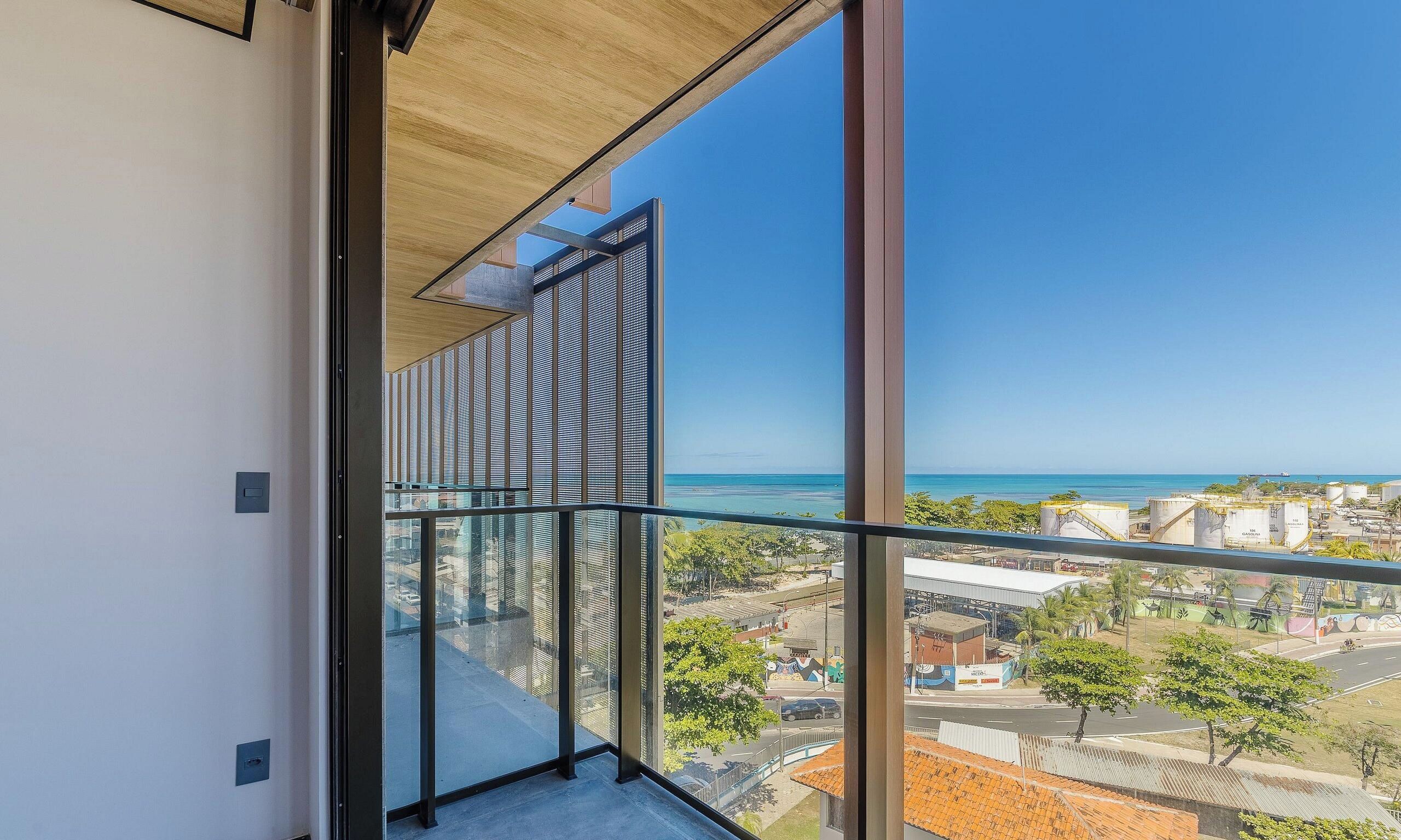 A balcony with a view of the ocean and a cityscape.