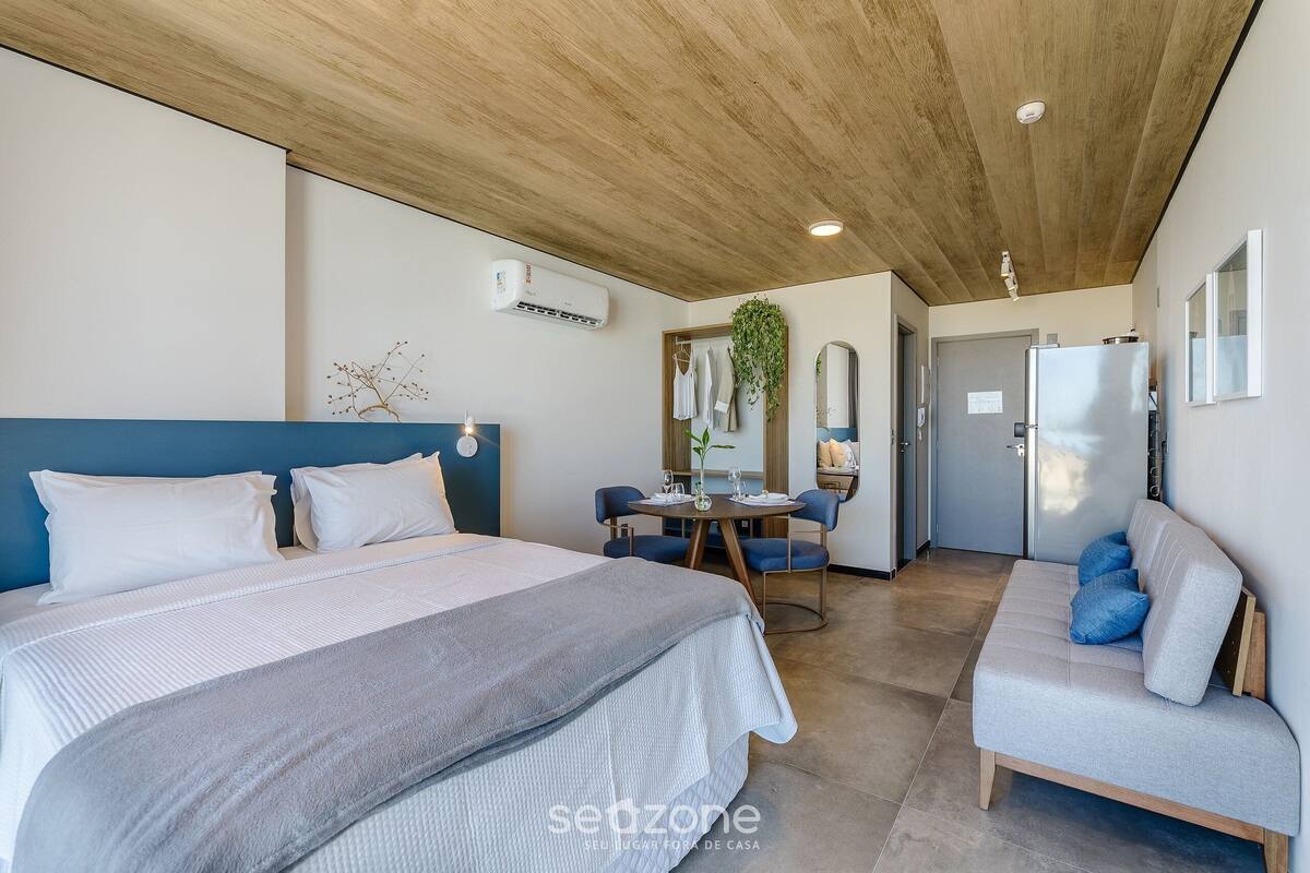 Una habitación de hotel moderna con una cama grande, un sofá, un comedor y un baño.