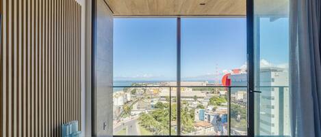 A balcony with a view of a coastal cityscape, including a port and industrial buildings.