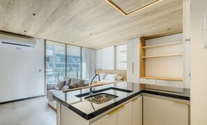 A modern kitchen with a glass island, a built-in oven, and a view of the city through large windows. - Nwts - Studios With Side sea View in Maceio III (Maceió)