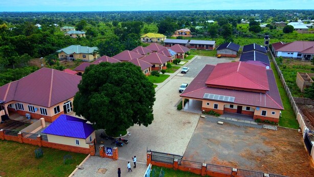 A residential area with multiple houses, some with solar panels, surrounded by greenery. - BowMarie Resort (Kpandai)