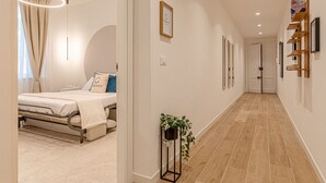 A modern hotel room with a bed, bedside table, and a potted plant. - Eternity Apartment – Luxury in the City (Civitanova Marche)