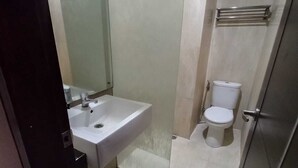 Une salle de bain moderne équipée d’un lavabo, de toilettes et d’une douche.