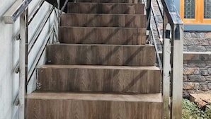 A staircase with wooden steps and metal railings, leading to an upper level. - Sarvik Residency (Tiruchirappalli)