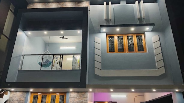 A two-story building with a balcony, a hanging chair, and a window with a wooden frame. - Sarvik Residency (Tiruchirappalli)