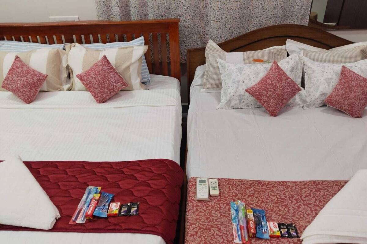 Zwei Betten mit je zwei Einzelbetten, rote und weiße Bettwäsche, Kissen und eine rote Decke auf dem unteren Bett.
