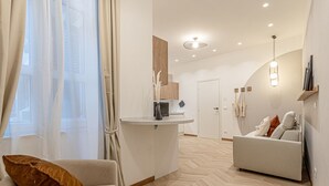 Un salon moderne comprenant un canapé, une table basse et un coin repas avec un comptoir.