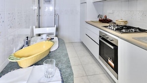 Una cucina moderna con mobili bianchi, un fornello a gas e un lavello.