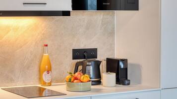 A modern kitchen with a built-in oven, a coffee machine, and a kettle.