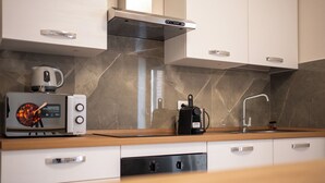 A modern kitchen with a microwave, kettle, coffee maker, and a dishwasher. - C&P Luxury Guest House Rome (Rome)