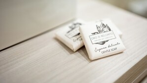 Two white soap bars with Italian text on a wooden surface. - C&P Luxury Guest House Rome (Rome)