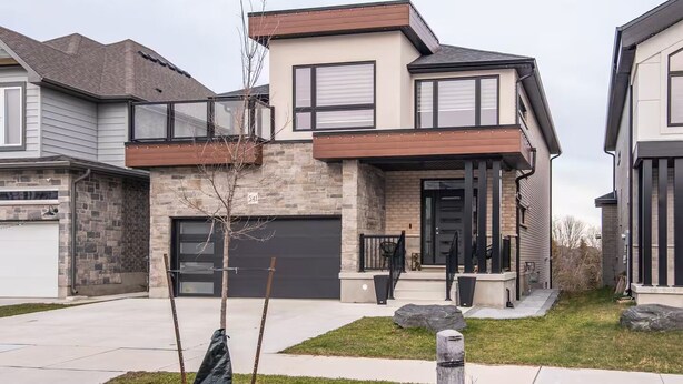 A modern two-story house with a stone facade, a garage, and a front porch. - The Simple Escape (Kitchener)