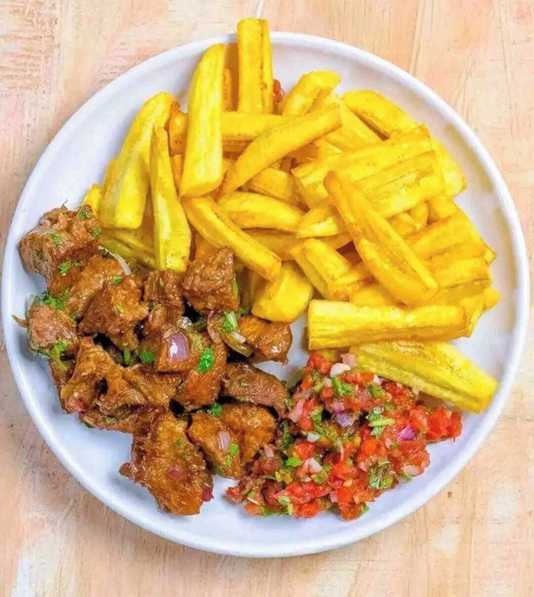 A plate with French fries, a meat dish, and a salsa.