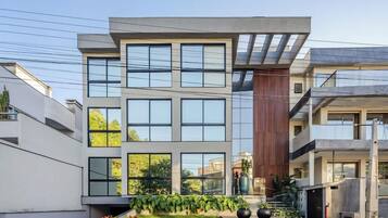 A modern multi-story building with large windows and a flat roof.