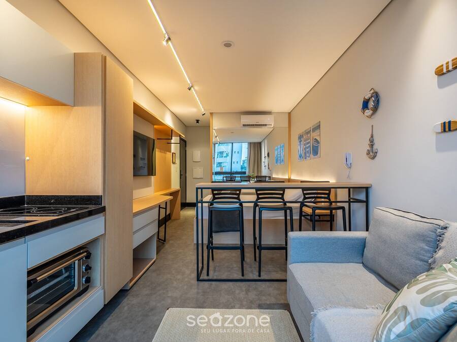 A modern kitchen with a built-in stove and bar stools.