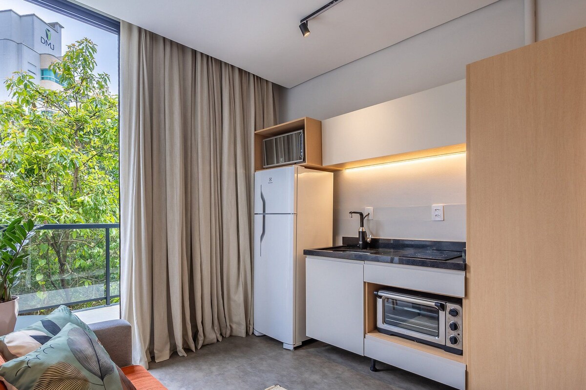A compact kitchen with a built-in oven, a microwave, and a sink.