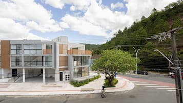 Een modern gebouw met meerdere verdiepingen, grote ramen en een combinatie van glazen en houten panelen.